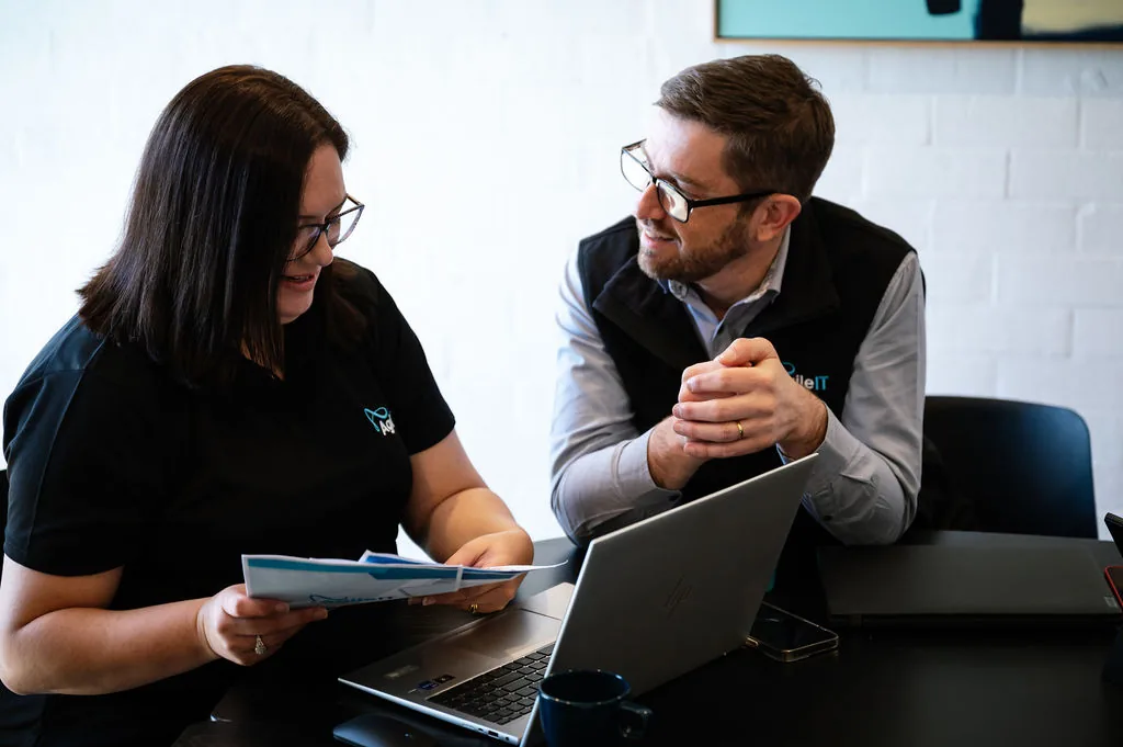 Linden Jackson in a working consultation with a colleague at the Agile IT Mornington office, reviewing technology decisions together.