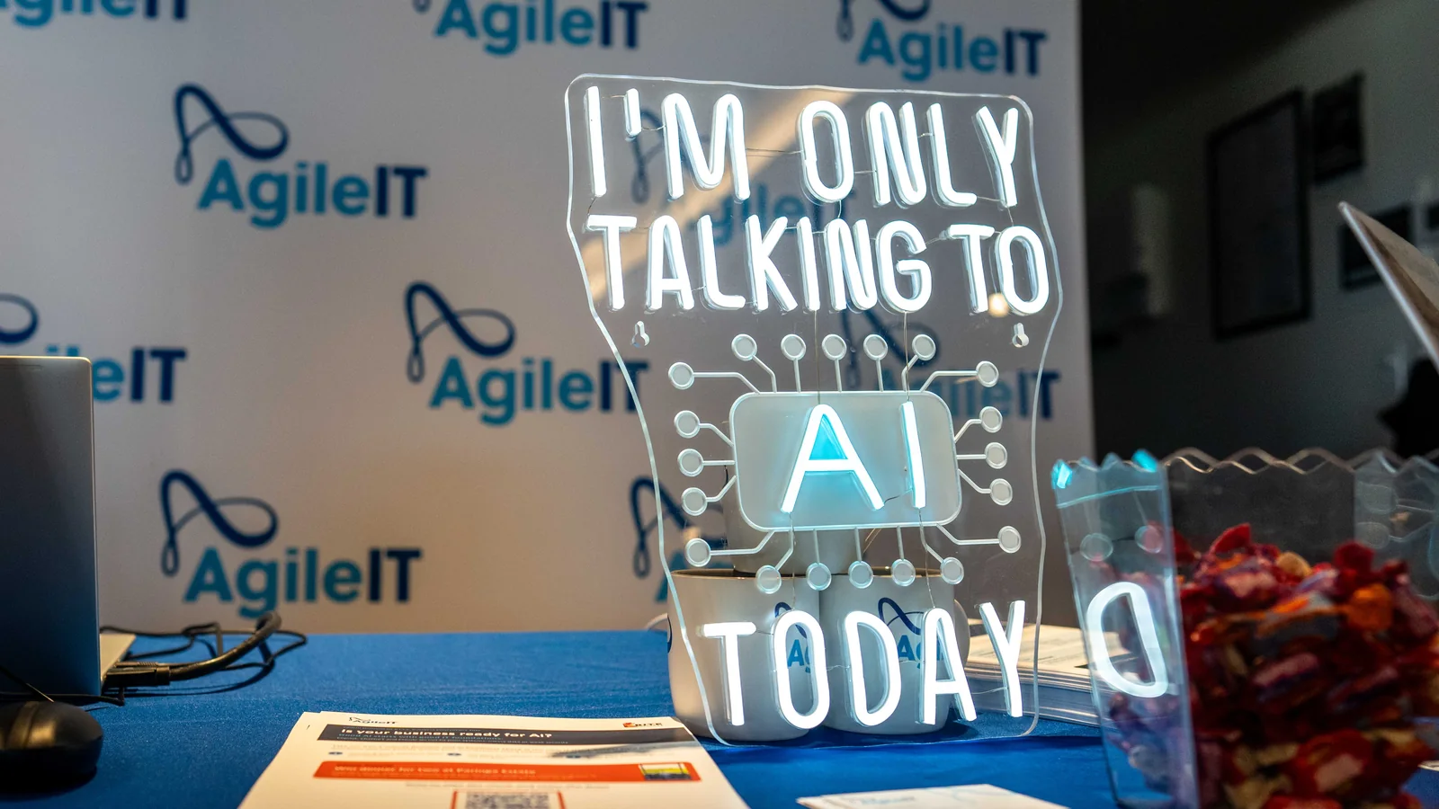 The neon sign on the Agile IT stand reading 