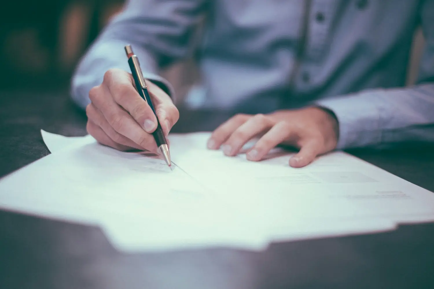 A business owner completing a cyber insurance renewal application at a desk.
