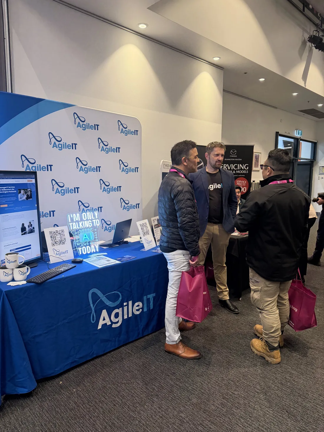 Visitors talking with the Agile IT team at the festival stand.
