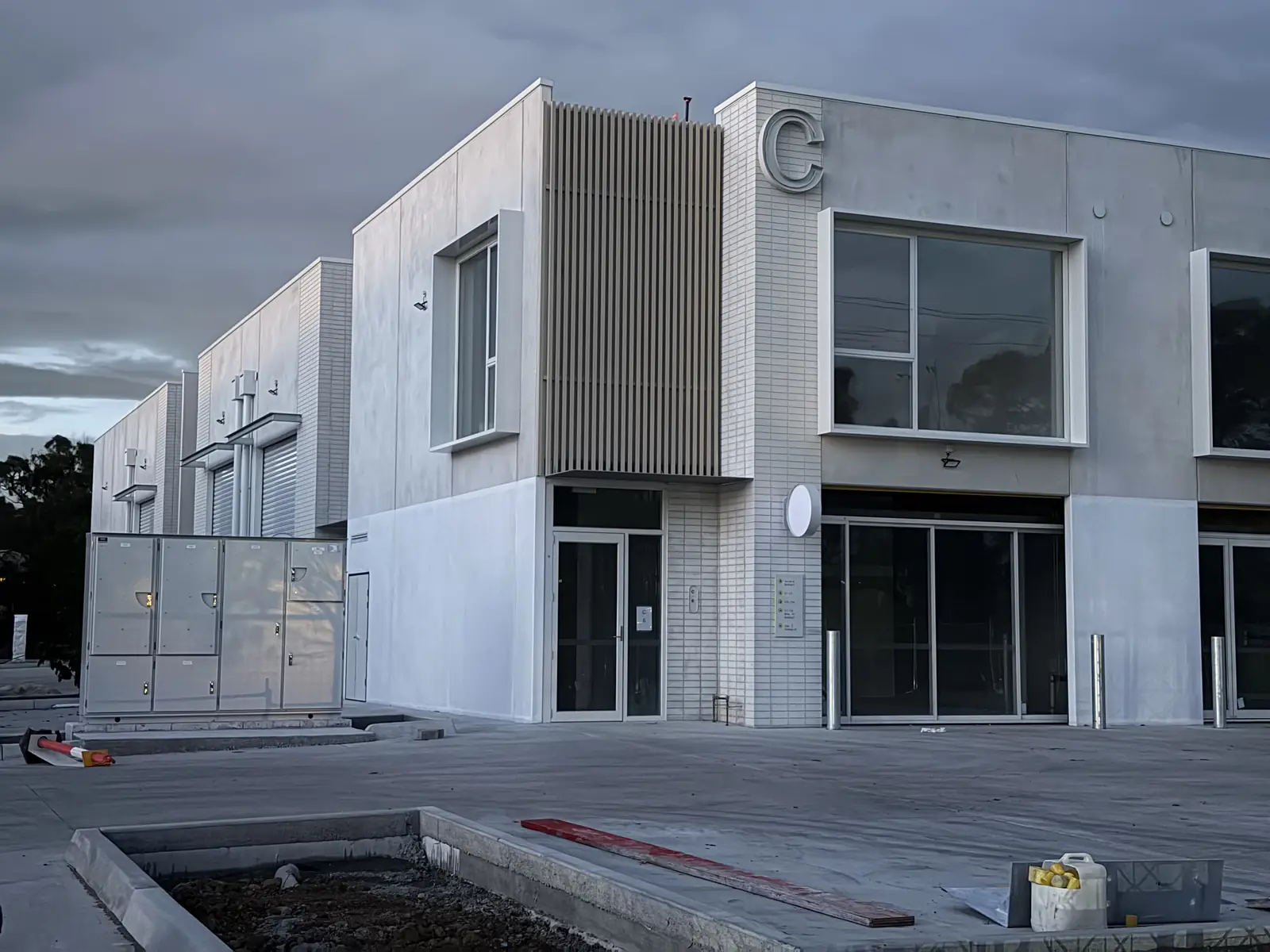 Wider angle of Building C from the side, showing neighbouring units and the timber slat feature