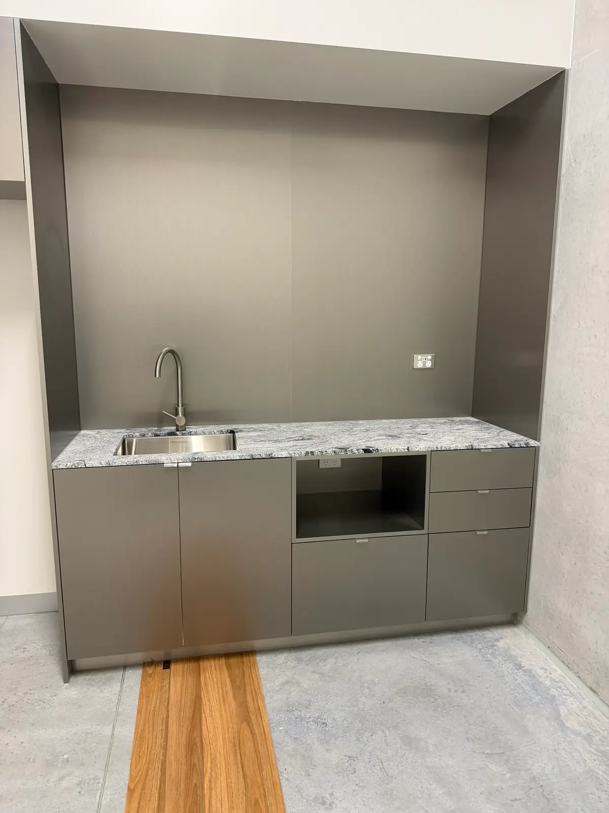 The new office kitchenette during fit-out, stone benchtop, stainless steel mixer tap and cabinetry installed
