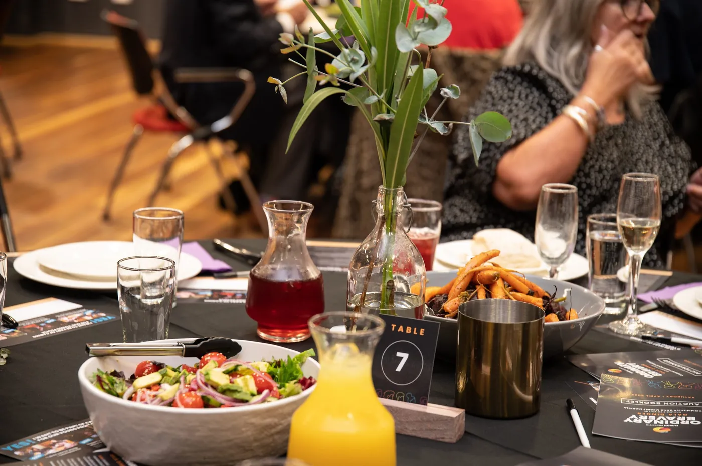 Guests dining at a beautifully set table at Fusion's A Night in the Vines Annual Gala.