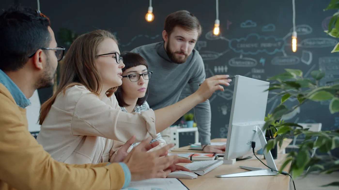 A small business team reviewing work together on screen