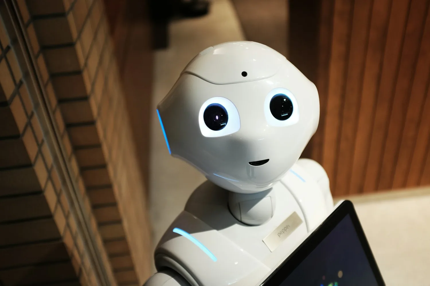 A friendly humanoid robot holding a tablet, representing approachable AI assistance for business