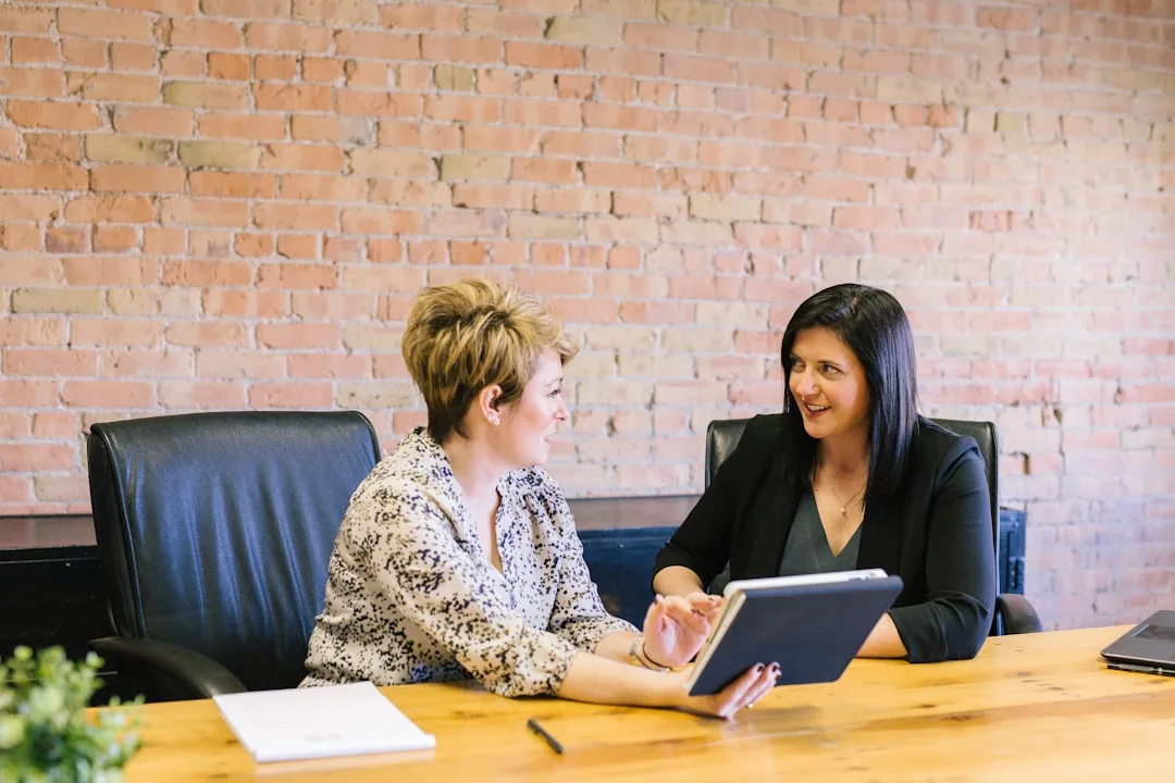 Two business professionals talking a decision through together in a meeting.