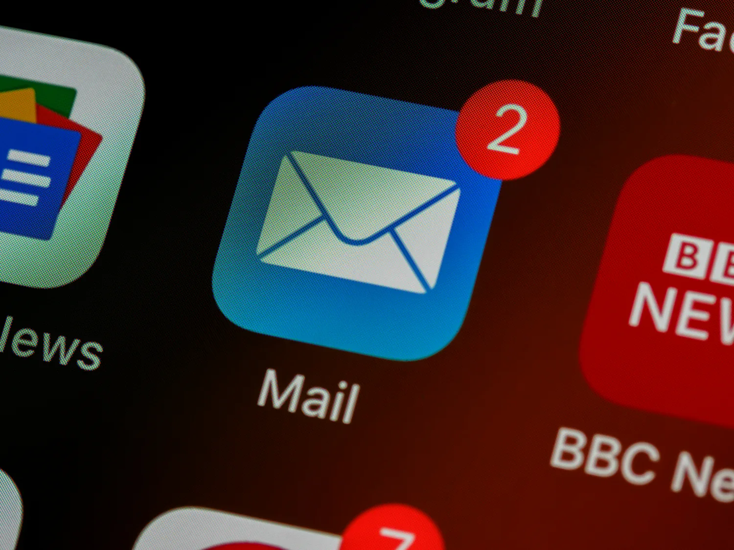 A close-up of a phone home screen showing the Mail app icon with unread notifications.