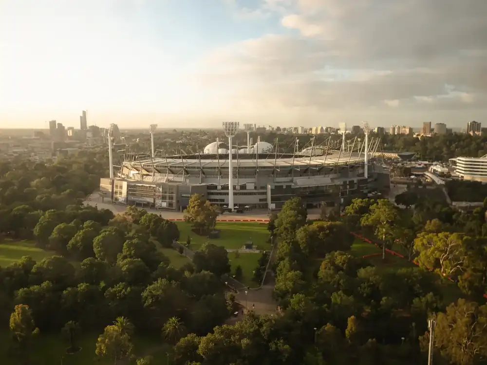 The Melbourne Cricket Ground at sunrise, with the Melbourne CBD skyline behind and the Yarra parklands in the foreground, the view our East Melbourne office looks out over