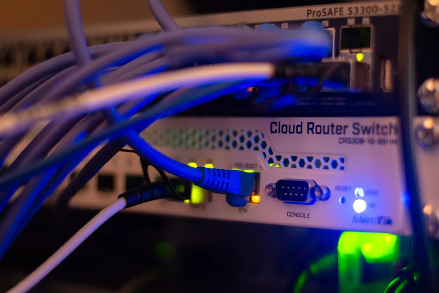 A managed network switch with patched Ethernet cables and status lights, the connectivity infrastructure behind AgileCONNECT business internet.