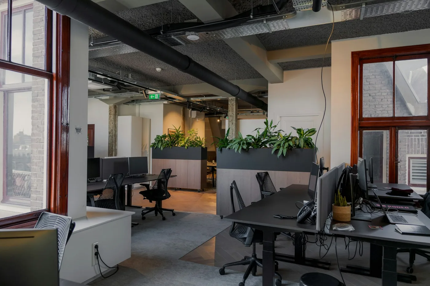 A modern office with multiple consistent workstations, dual-monitor setups and matching chairs, signalling a deliberately standardised technology environment.