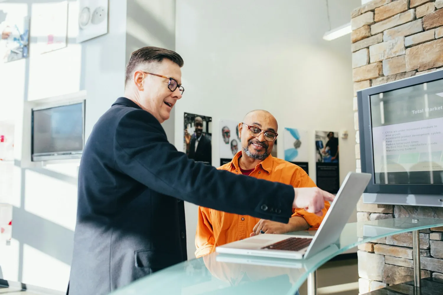 An Agile IT support specialist confidently helping a client at a laptop, the onsite support and full-service partnership of AgileCOMPLETE.