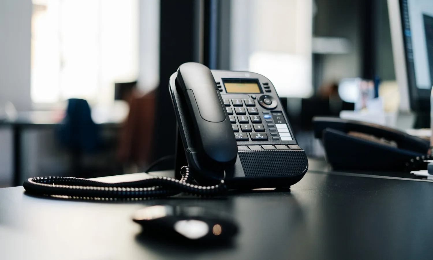 A modern VoIP desk phone on an office desk, AgileVOICE delivers hosted voice and Microsoft Teams calling in one integrated service.